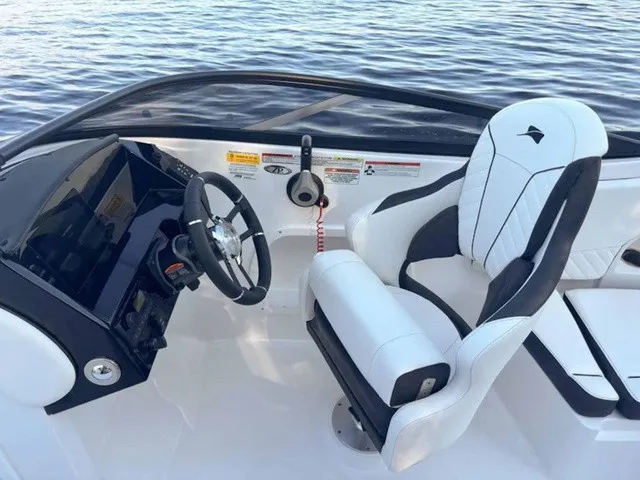 Slide: The Image of The image shows the cockpit of a Stingray 23 OSX boat with a modern helm and cushioned seat. - 13