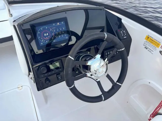 Slide: The Image of The image shows the helm of a 2027 Stingray 23 OSX boat with a modern display. - 15
