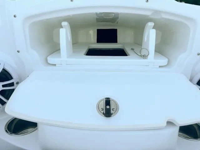 Slide: The Image of An open storage compartment on a boat with speakers and a latch. - 10