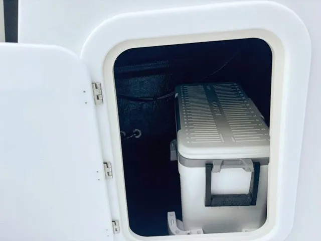 Slide: The Image of A white storage compartment with a cooler inside, on a boat. - 24