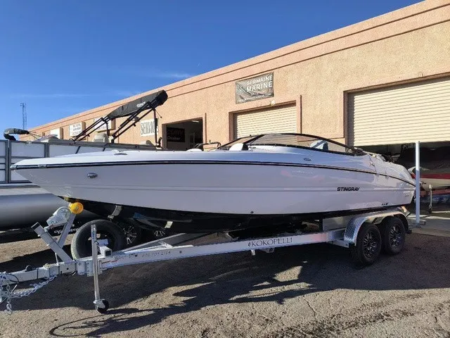 Slide: The Image of A white Stingray 23 OSX boat from 2027 sits on a trailer in front of a building. - 25
