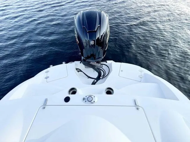 Slide: The Image of The image shows the stern of a white boat with an outboard motor on calm water. - 23