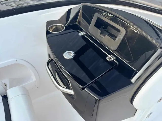 Slide: The Image of The image shows the cockpit of a Stingray 23 OSX boat with a black dashboard and cup holder. - 16