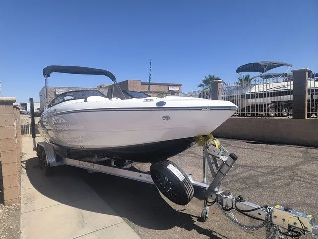 Slide: The Image of A white Stingray 23 OSX boat from 2027 is on a trailer in a sunny yard. - 30