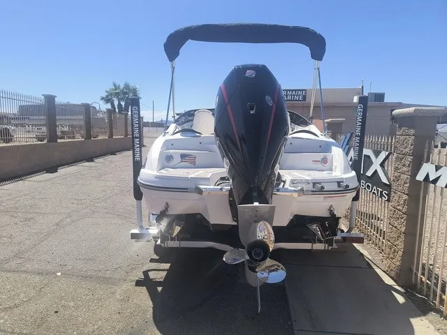 Slide: The Image of A white boat with a black outboard motor is on a trailer in a fenced area. - 28