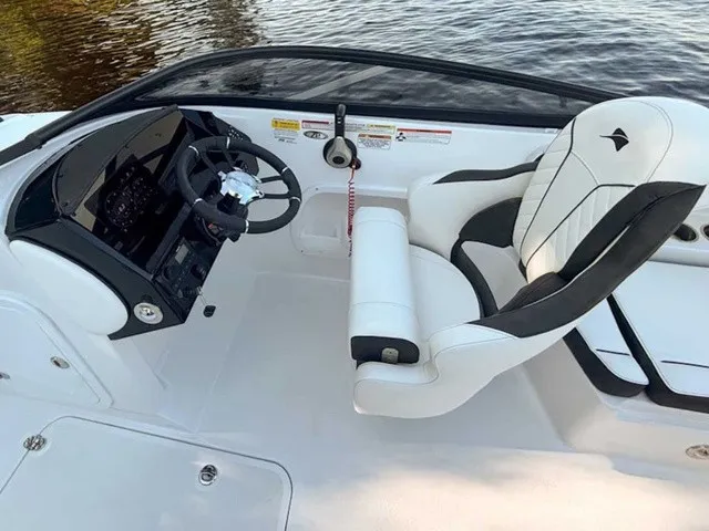 Slide: The Image of The image shows the cockpit of a Stingray 23 OSX boat with a sleek white seat and modern helm. - 14