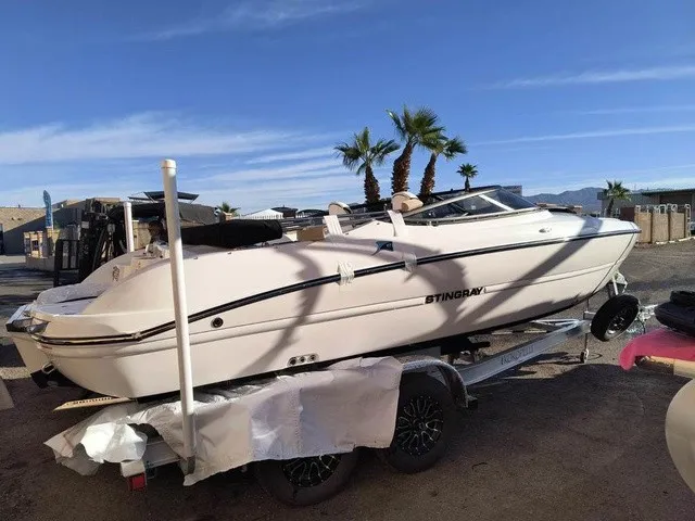 Slide: The Image of A white Stingray 23 OSX boat from 2027 is on a trailer in a sunny setting. - 32