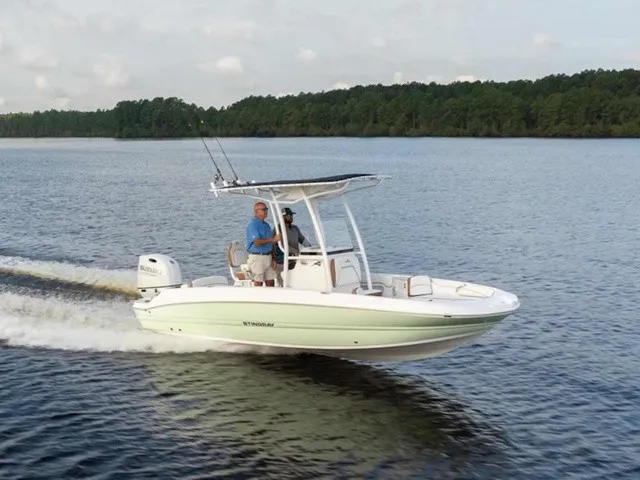 The Image of A modern motorboat with a T-top cruising on calm waters, surrounded by trees. - 2