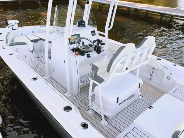 Slide: The Image of A modern 2027 Stingray 20 CC with white interior and gray accents, docked by the water. - 13