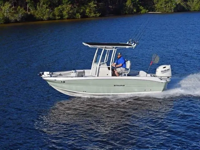 Slide: The Image of A 2027 Stingray 20 CC boat speeds across calm water, surrounded by trees. - 10