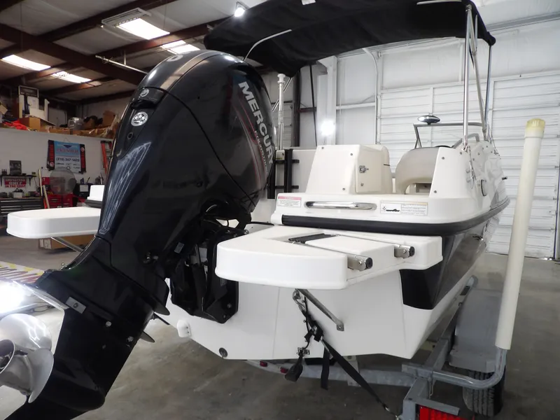 Slide: The Image of A 2013 Bayliner 190 Deck Boat with a Mercury outboard motor in a storage facility. - 9