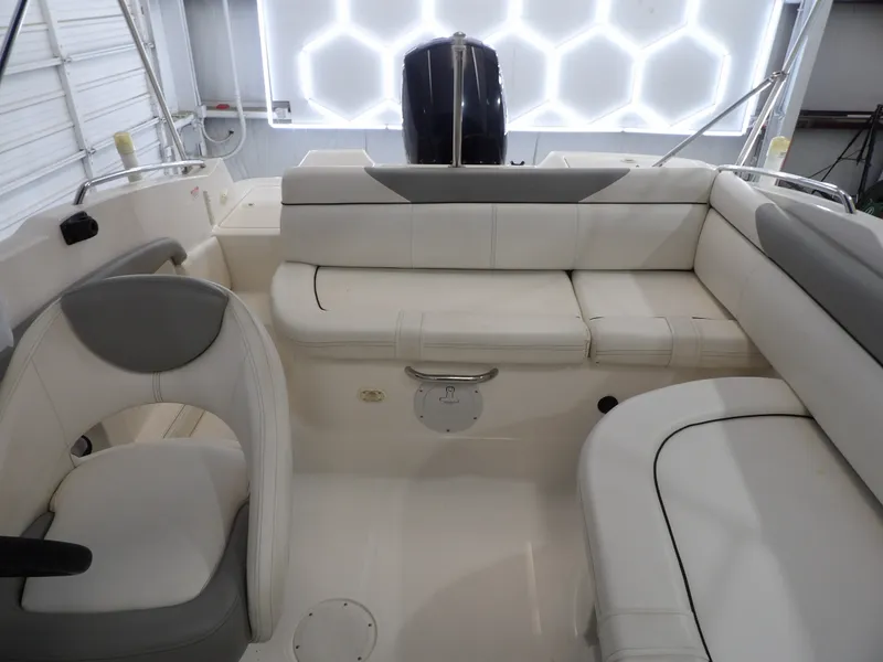 Slide: The Image of The image shows the cockpit of a 2013 Bayliner 190 Deck Boat with white upholstery. - 19