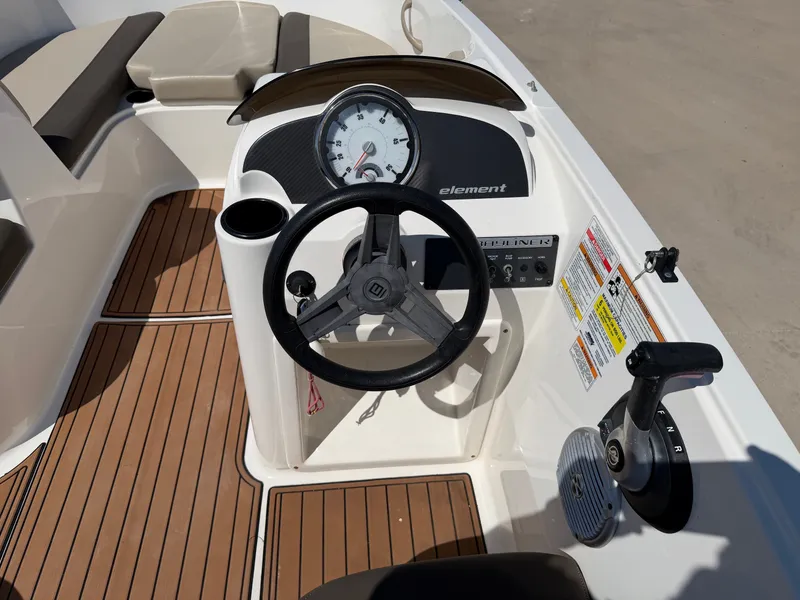 Slide: The Image of The image shows the cockpit of a 2017 Bayliner Element 16 with a steering wheel and console. - 19