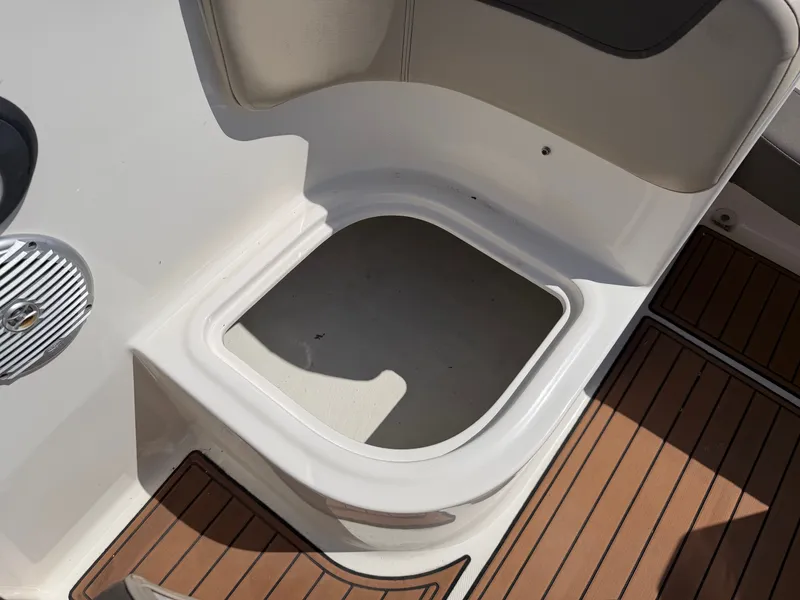 Slide: The Image of An open storage compartment on a 2017 Bayliner Element 16 boat, surrounded by cushioned seating. - 21