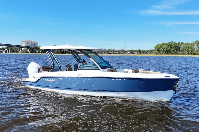 Slide: The Image of 2025 Monterey Elite 27 OB boat cruising on a sunny day, blue water and clear sky. - 3