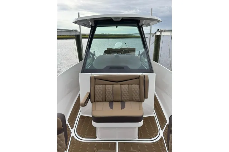 Slide: The Image of 2025 Monterey Elite 27 OB boat interior with tan seating and sleek design. - 44