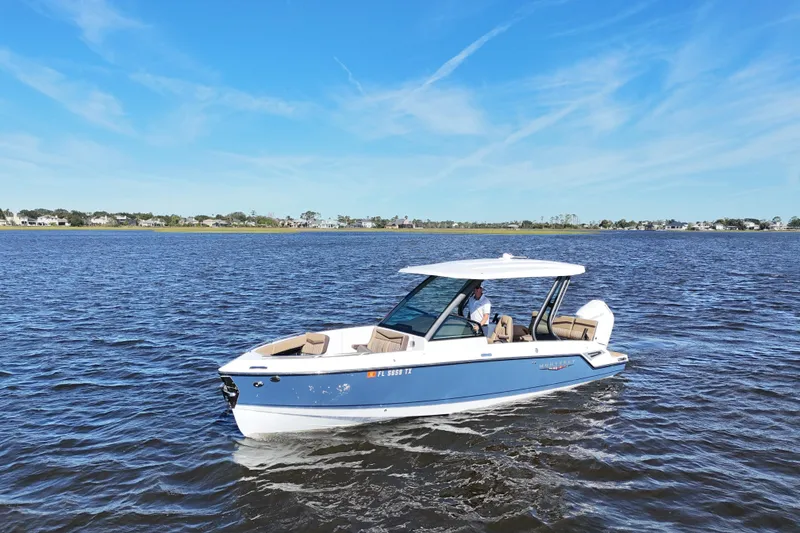 Slide: The Image of 2025 Monterey Elite 27 OB boat cruising on a calm lake under a clear blue sky. - 9