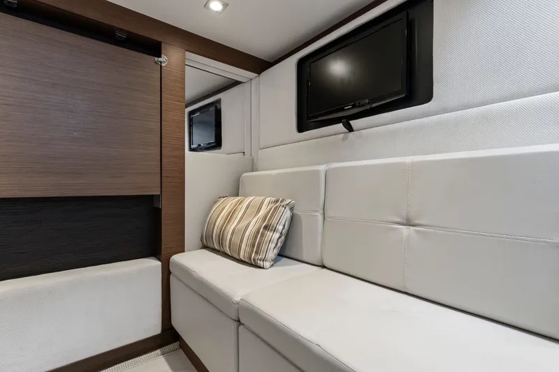Slide: The Image of Interior of 2013 Sea Ray 410 Sundancer yacht with plush seating and wall-mounted TV. - 23