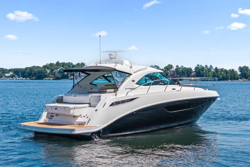 Slide: The Image of 2013 Sea Ray 410 Sundancer yacht on calm water, clear sky background. - 2
