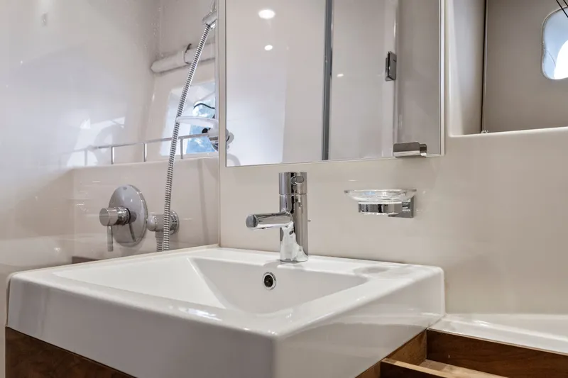 Slide: The Image of Modern bathroom sink on 2013 Sea Ray 410 Sundancer yacht, featuring sleek fixtures and mirror. - 10
