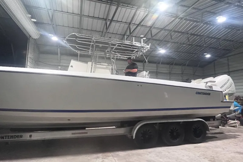 Slide: The Image of 2005 Contender 35 ST boat on trailer in a well-lit indoor storage facility. - 9