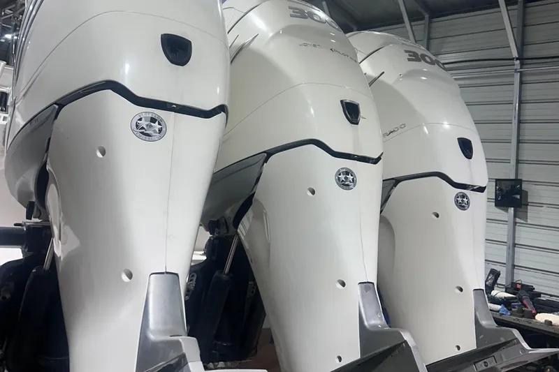 Slide: The Image of Three powerful outboard motors on a 2005 Contender 35 ST boat in a garage. - 12