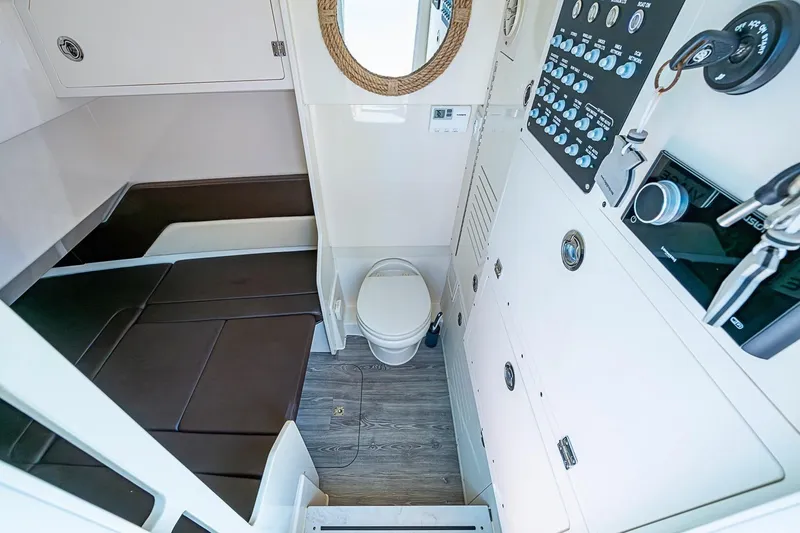 Slide: The Image of 2021 Scout 330 LXF cabin interior with toilet, control panel, and seating area. - 16
