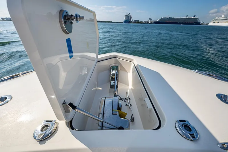 Slide: The Image of Open anchor compartment on 2021 Scout 330 LXF boat, with ocean and ships in background. - 12