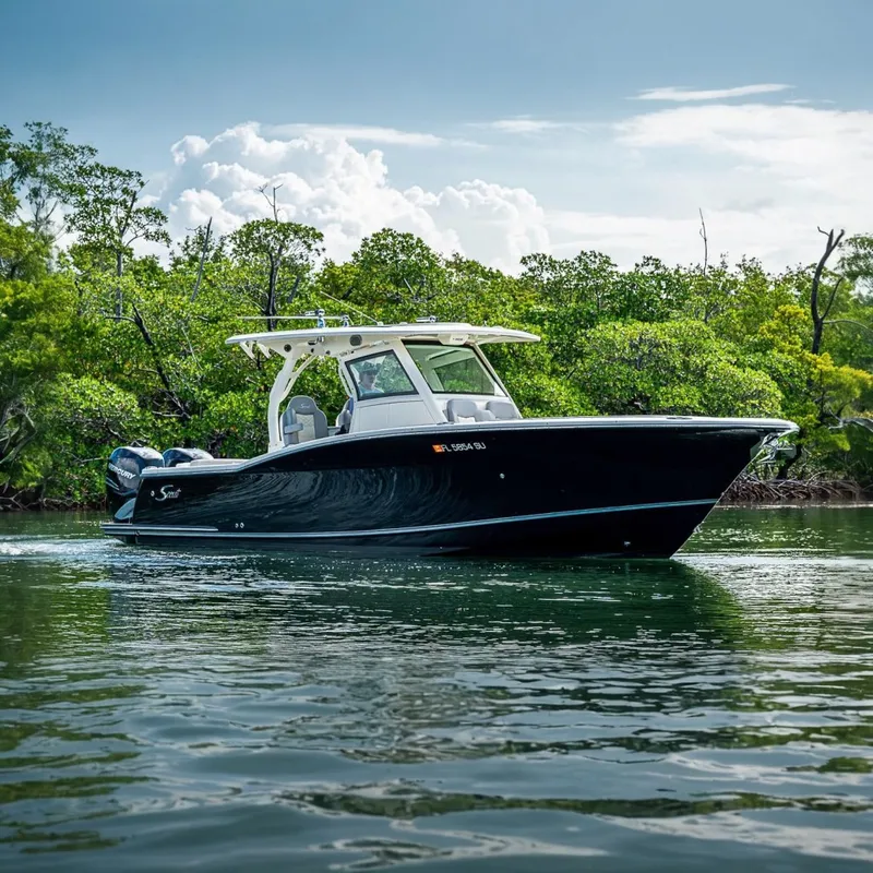 Slide: The Image of 2021 Scout 330 LXF boat cruising on calm water near lush greenery. - 5