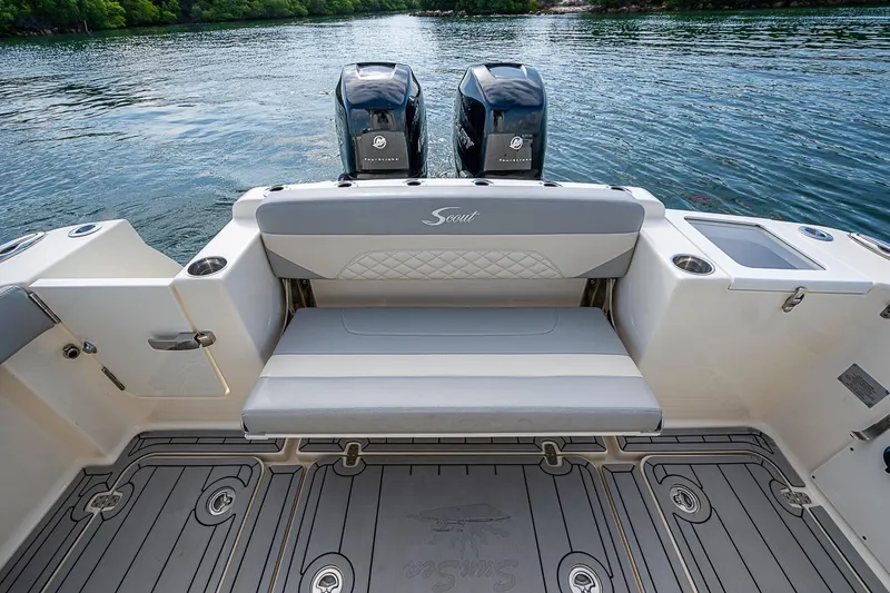 Slide: The Image of 2021 Scout 330 LXF boat interior with seating and twin engines on a calm lake. - 29