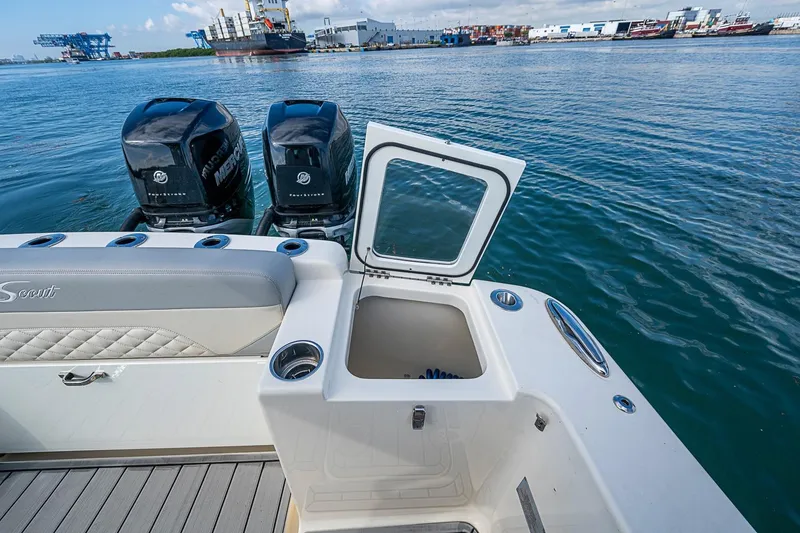 Slide: The Image of 2021 Scout 330 LXF boat with open storage compartment and twin Mercury engines. - 32