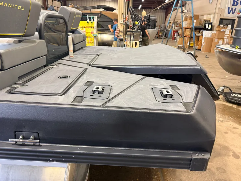 Slide: The Image of The image shows the rear of a Manitou 22 Explore Tritoon with gray upholstery and black details. - 47