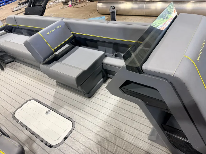 Slide: The Image of Interior of a Manitou 22 Explore Tritoon with gray upholstery and a modern helm station. - 28