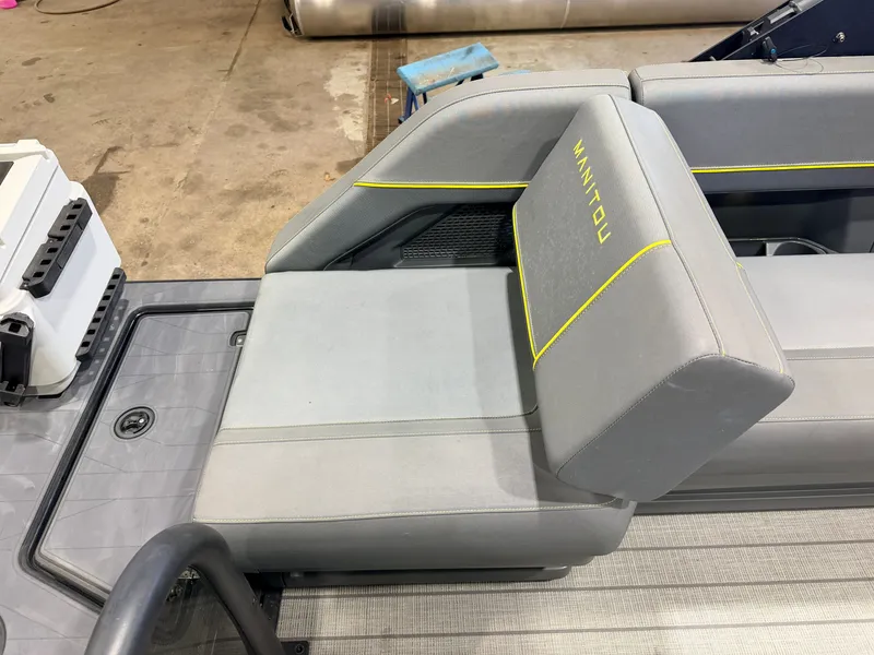 Slide: The Image of Gray seating with yellow Manitou logo on a boat. - 38