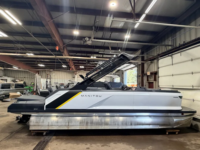 Slide: The Image of A 2023 Manitou 22 Explore Tritoon with 150HP Rotax engine is in a warehouse. - 18