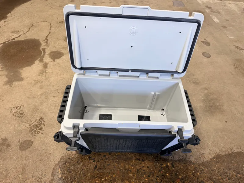 Slide: The Image of An open cooler with a sturdy design and black handles on a concrete floor. - 46