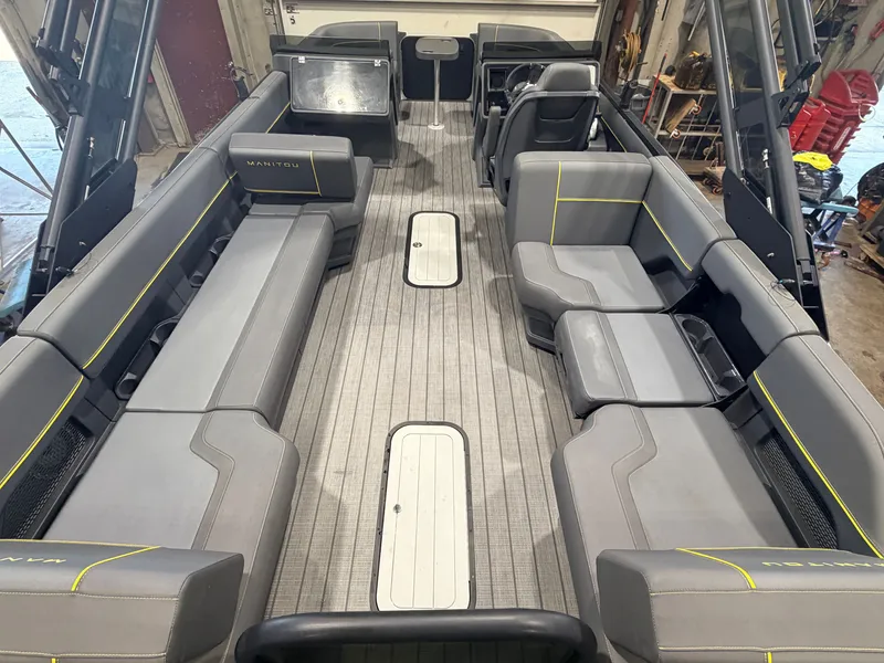 Slide: The Image of The image shows the interior of a 2023 Manitou 22 Explore Tritoon. It features gray upholstery and a modern design. - 7