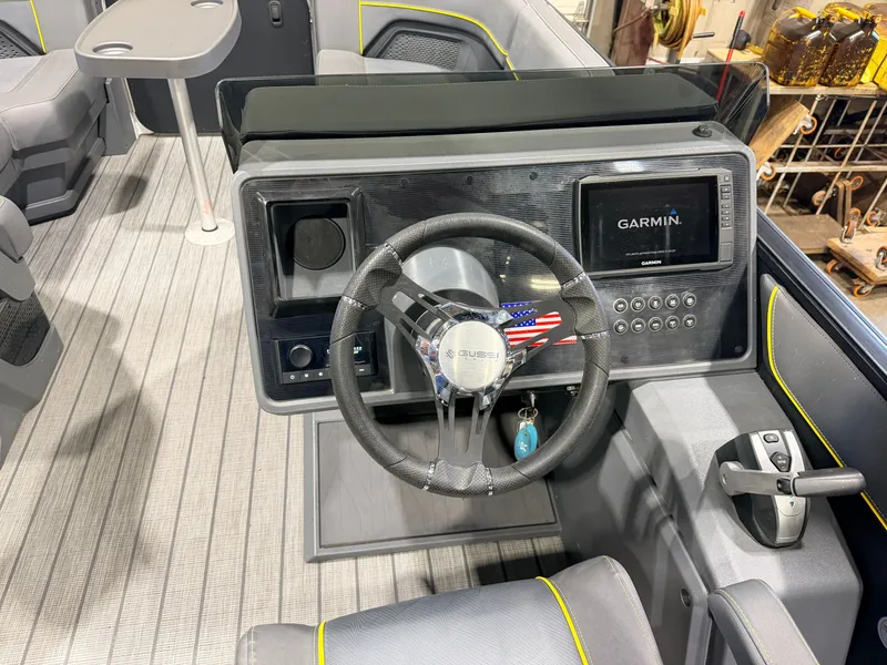 Slide: The Image of The image shows the helm of a 2023 Manitou 22 Explore Tritoon with a Garmin display. - 26