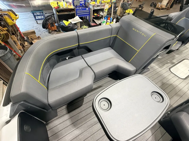 Slide: The Image of Gray seating area with yellow stitching on a boat, table with cup holders in the foreground. - 16