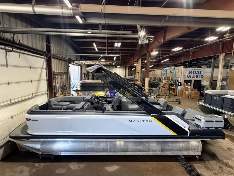 Slide: The Image of A 2023 Manitou 22 Explore Tritoon with 150HP Rotax engine in a warehouse setting. - 3
