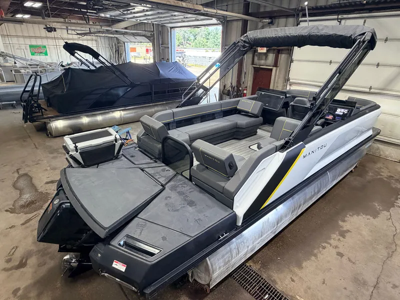 Slide: The Image of A 2023 Manitou 22 Explore Tritoon with 150HP Rotax engine in a warehouse setting. - 6