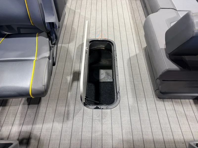 Slide: The Image of An open storage compartment in the floor of a boat with gray seats and yellow stitching. - 40