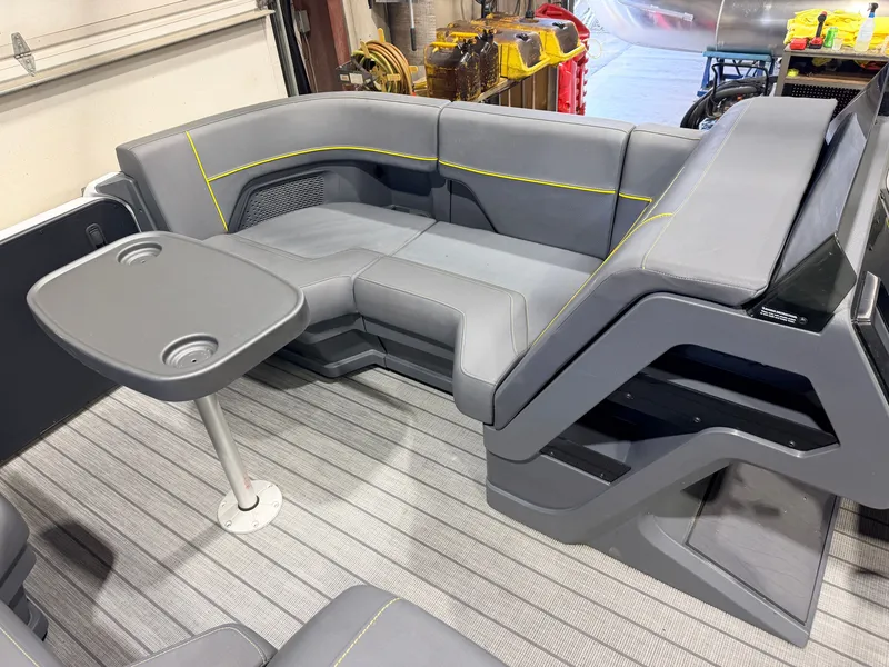 Slide: The Image of Interior of a Manitou 22 Explore Tritoon with gray seating and a small table. - 14