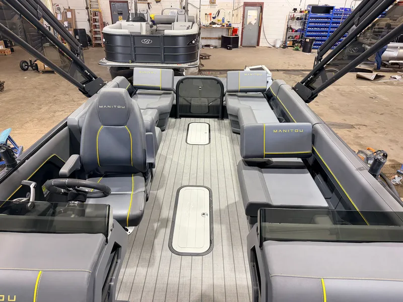Slide: The Image of Interior of a Manitou 22 Explore Tritoon with gray seating and yellow accents. - 4