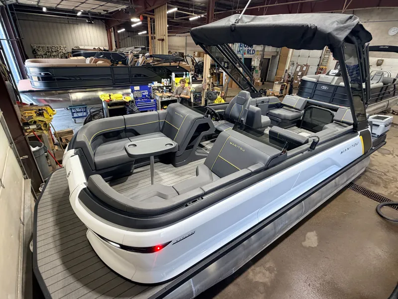 The Image of A modern 2023 Manitou 22 Explore Tritoon with gray seating and a small table. - 1