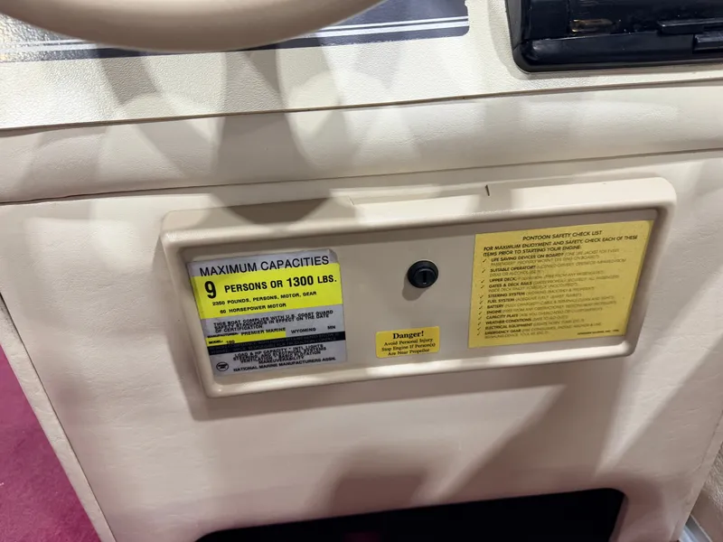 Slide: The Image of Close-up of a boat dashboard with capacity notes for 9 persons or 1300 pounds. - 25