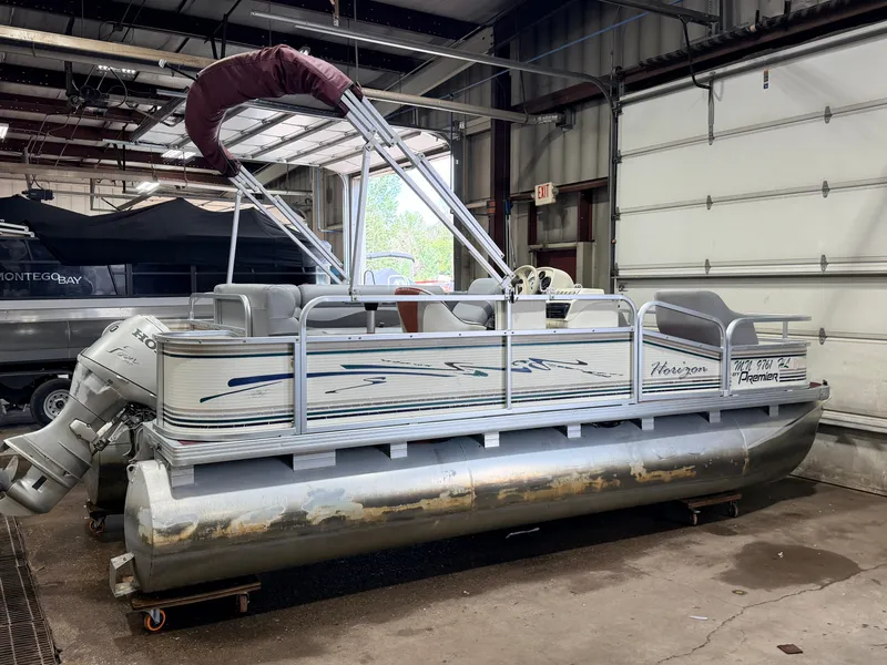 Slide: The Image of A 1998 Premier 180 Horizon pontoon boat with a 40HP Honda 4-stroke engine in a garage. - 47