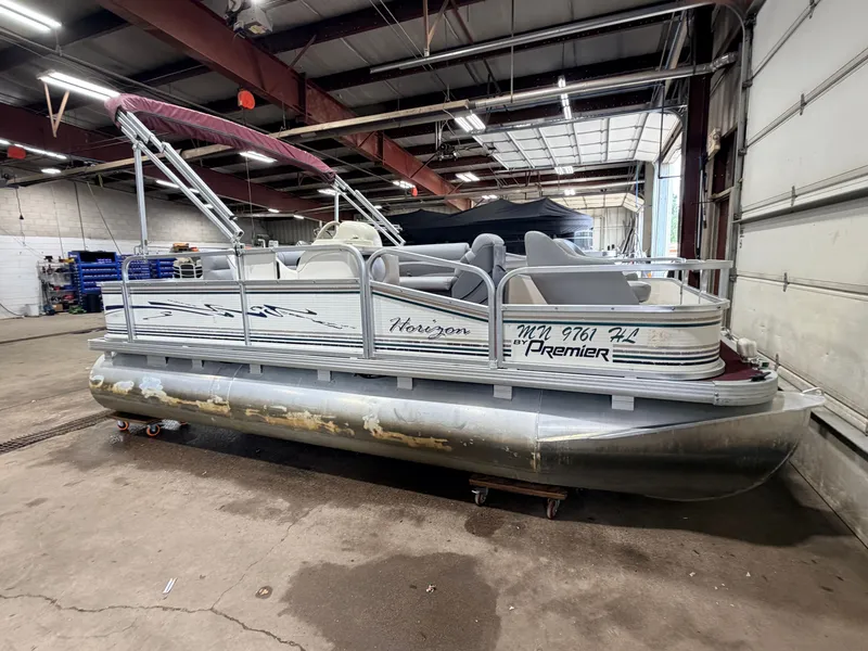 Slide: The Image of A 1998 Premier 180 Horizon pontoon boat with a 40HP Honda 4-stroke engine in a warehouse. - 49