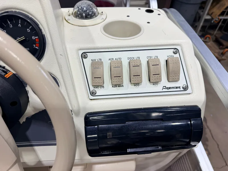 Slide: The Image of The image shows the dashboard of a Premier boat with various switches and a speedometer. - 23