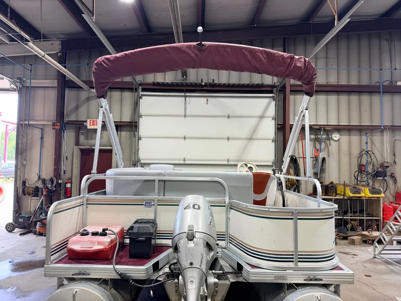 Slide: The Image of A 1998 Premier 180 Horizon pontoon boat with a 40HP Honda 4-stroke engine in a workshop. - 44